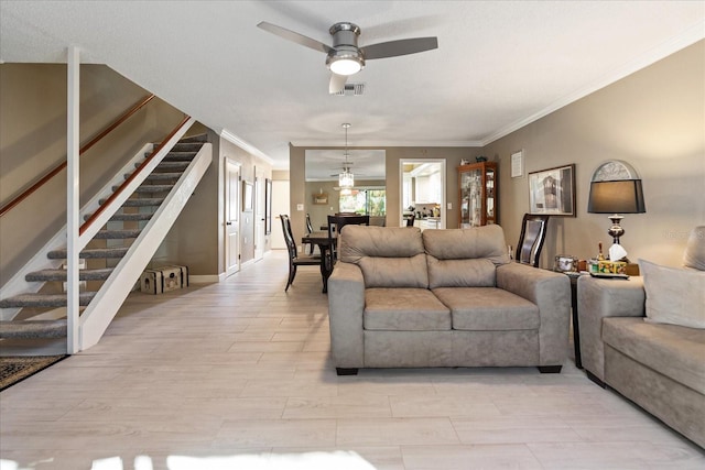 living room featuring ceiling fan and crown molding