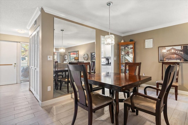 dining space featuring an inviting chandelier, ornamental molding, and a textured ceiling