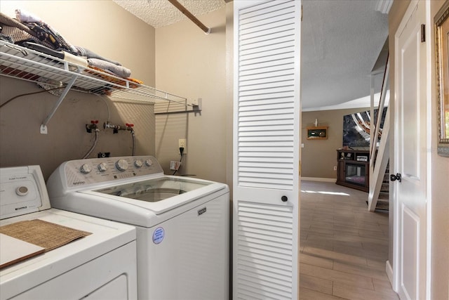 laundry room featuring a textured ceiling and independent washer and dryer