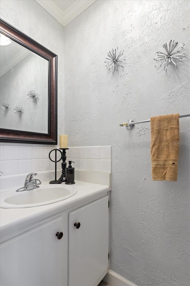 bathroom with vanity, ornamental molding, and tasteful backsplash