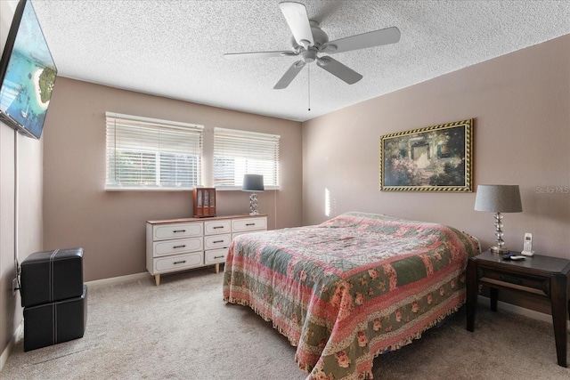 carpeted bedroom featuring ceiling fan and a textured ceiling