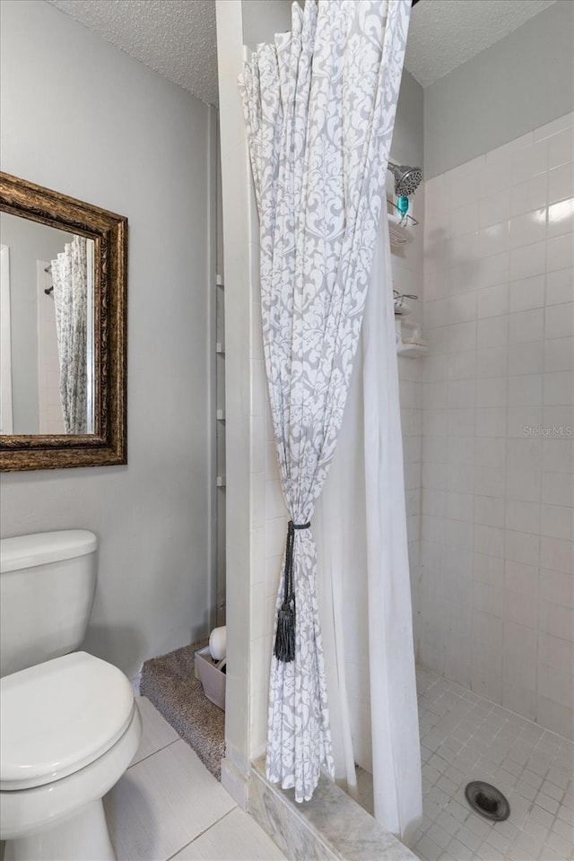 bathroom with a shower with curtain, tile patterned flooring, a textured ceiling, and toilet