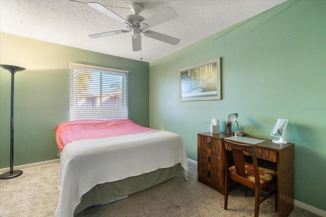 bedroom featuring light colored carpet, ceiling fan, and a textured ceiling