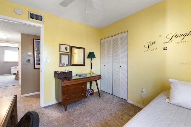 carpeted bedroom with ceiling fan and a closet