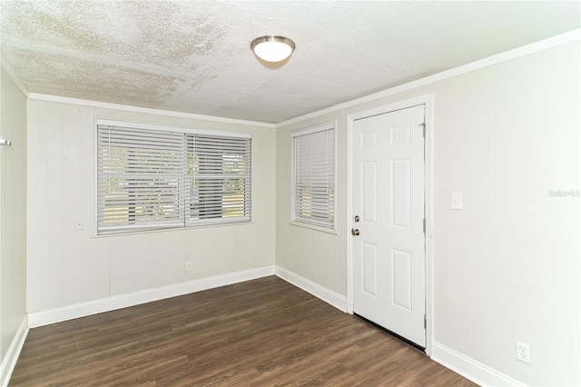 empty room featuring crown molding, dark hardwood / wood-style floors, and a textured ceiling