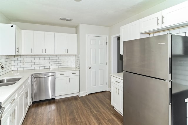 kitchen with tasteful backsplash, white cabinetry, sink, dark hardwood / wood-style flooring, and stainless steel appliances