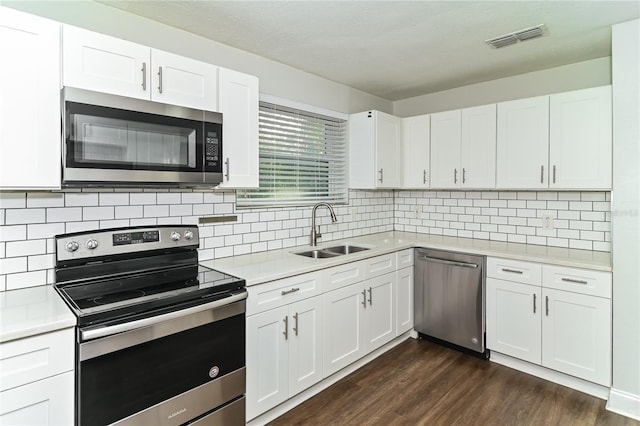 kitchen with white cabinetry, appliances with stainless steel finishes, sink, and tasteful backsplash