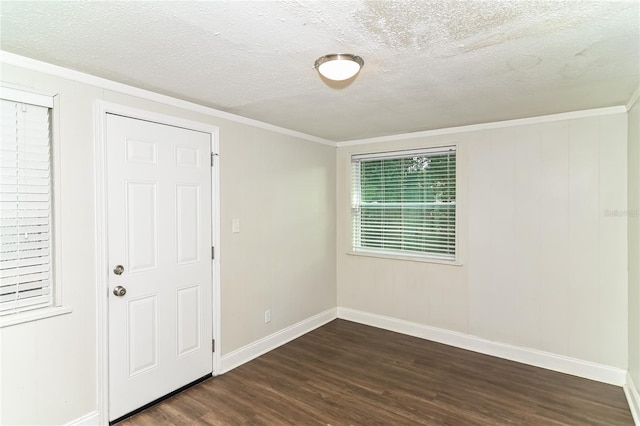 empty room with dark wood-type flooring, ornamental molding, and a textured ceiling