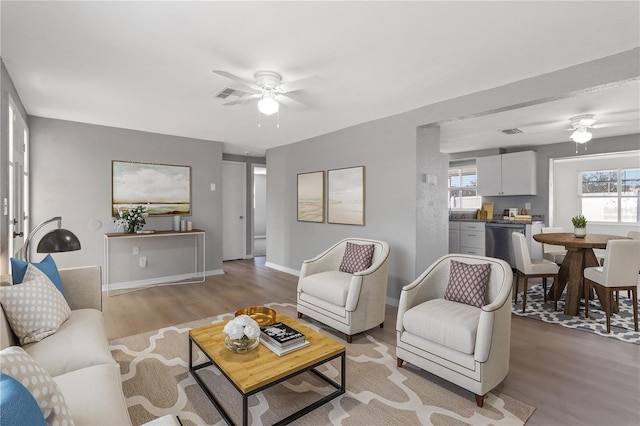 living room featuring ceiling fan, a healthy amount of sunlight, and light hardwood / wood-style floors