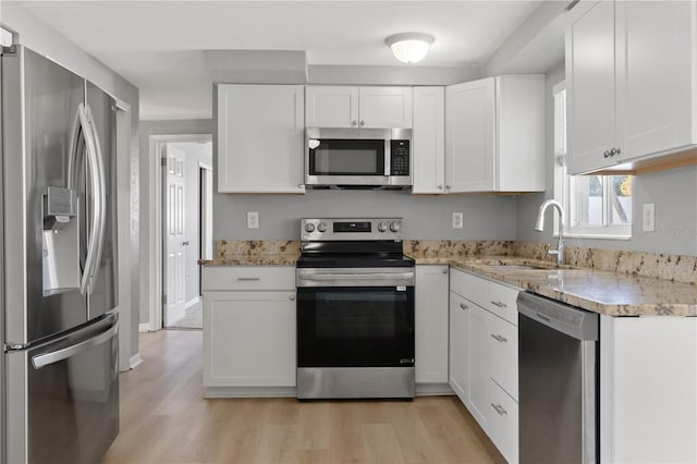 kitchen with appliances with stainless steel finishes, white cabinetry, and sink