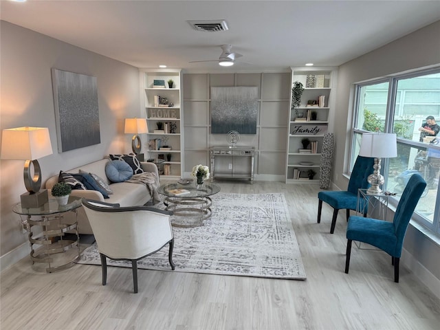 living room with ceiling fan, light hardwood / wood-style flooring, and built in features