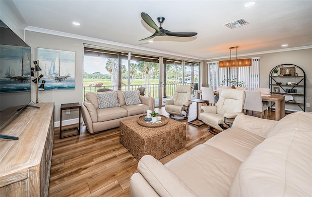 living room with ceiling fan, plenty of natural light, hardwood / wood-style floors, and crown molding