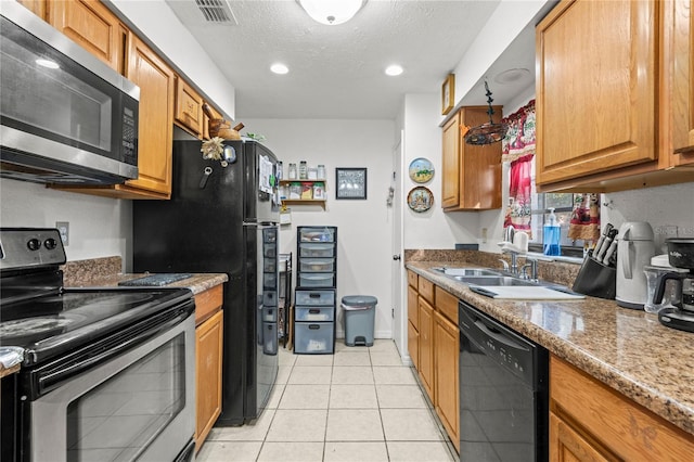 kitchen featuring sink, a textured ceiling, light stone counters, light tile patterned flooring, and black appliances