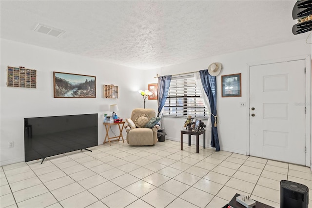 interior space with a textured ceiling and light tile patterned floors