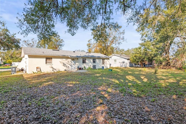 rear view of property featuring a lawn