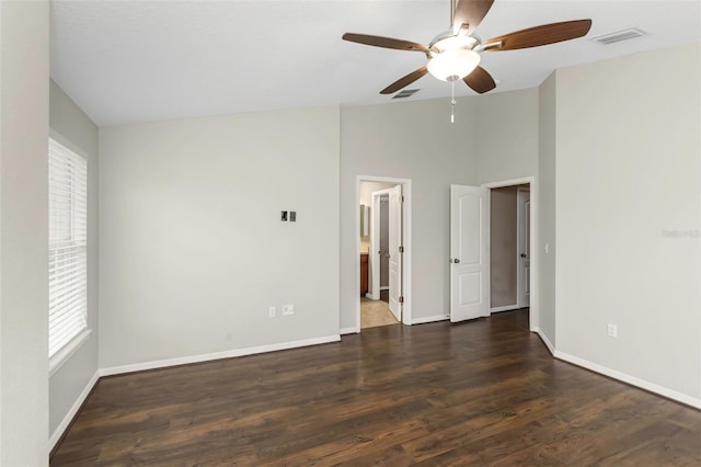 spare room featuring dark wood-type flooring, plenty of natural light, and ceiling fan