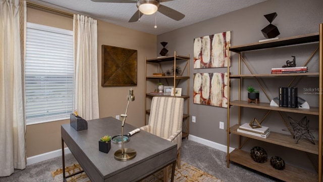 carpeted office space featuring a textured ceiling and ceiling fan