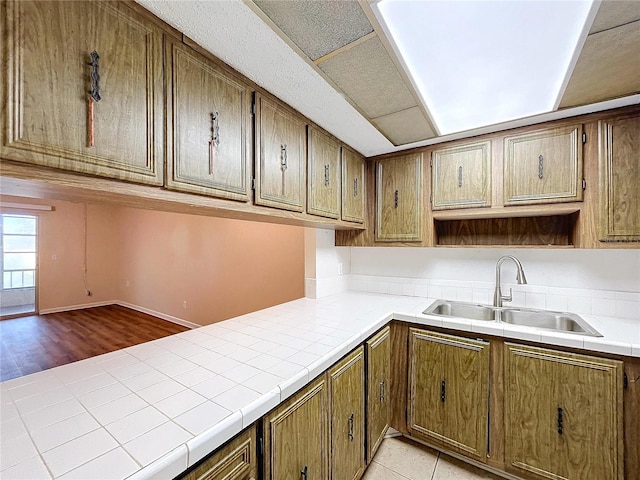 kitchen featuring sink, light tile patterned floors, and tile counters