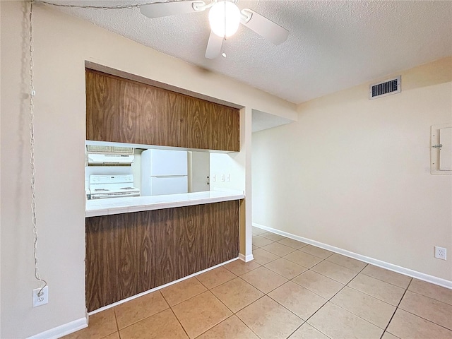 kitchen featuring ceiling fan, white appliances, a textured ceiling, and light tile patterned flooring