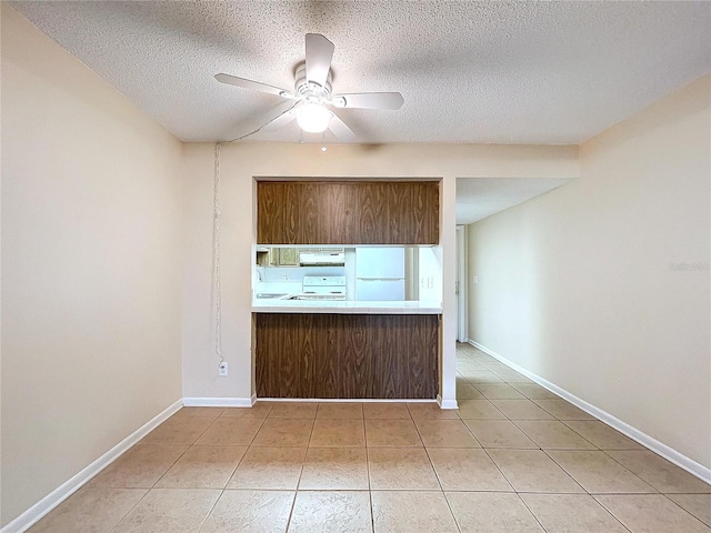 kitchen with ceiling fan, white appliances, tile patterned floors, and a textured ceiling