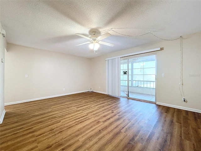 empty room with ceiling fan, dark wood-type flooring, and a textured ceiling