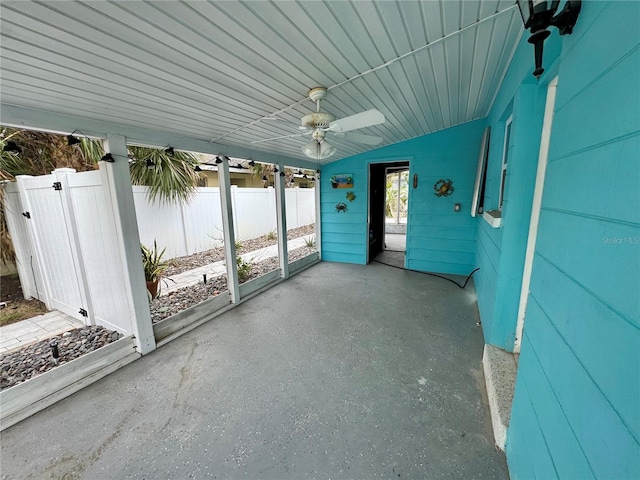 unfurnished sunroom with ceiling fan and vaulted ceiling