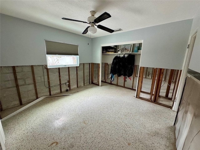 bedroom featuring ceiling fan, a closet, and a textured ceiling