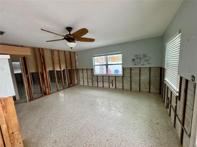 empty room with a textured ceiling and ceiling fan