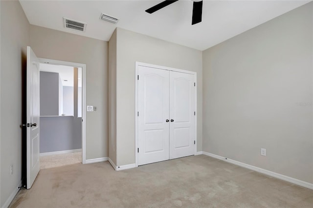 unfurnished bedroom with ceiling fan, a closet, and light carpet