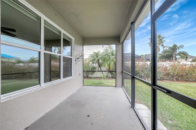 unfurnished sunroom with ceiling fan