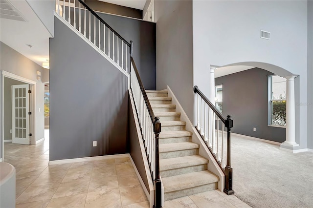 stairway featuring carpet floors and ornate columns