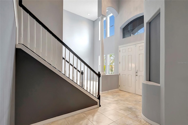 foyer entrance with a high ceiling and light tile patterned floors