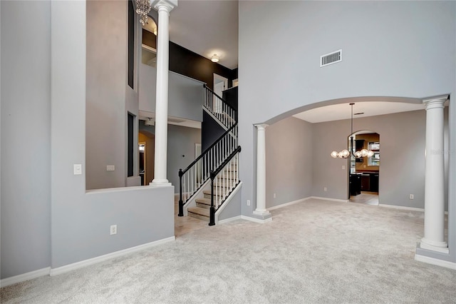 unfurnished living room featuring carpet floors, a high ceiling, and a notable chandelier