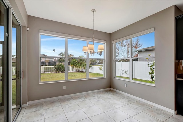 unfurnished dining area featuring an inviting chandelier, light tile patterned floors, and a healthy amount of sunlight