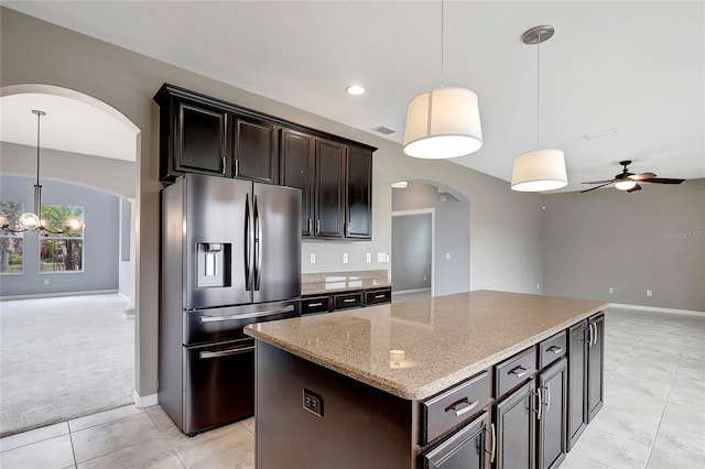 kitchen with decorative light fixtures, stainless steel fridge, a center island, and ceiling fan with notable chandelier