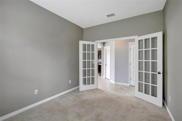 spare room with light colored carpet and french doors