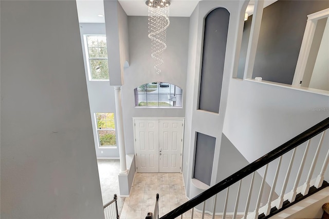 tiled foyer entrance with a high ceiling and an inviting chandelier