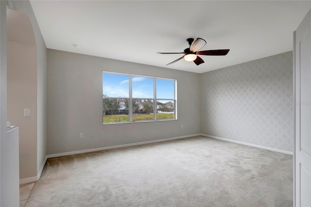 carpeted spare room with ceiling fan