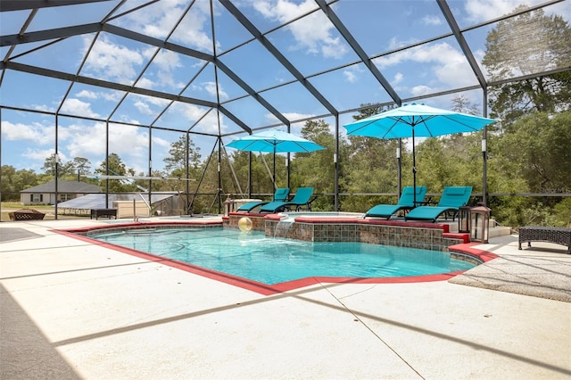 view of pool featuring pool water feature, glass enclosure, a patio area, and an in ground hot tub