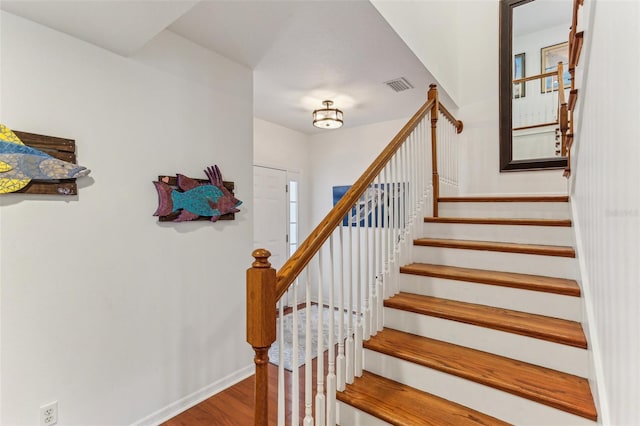 staircase featuring wood-type flooring