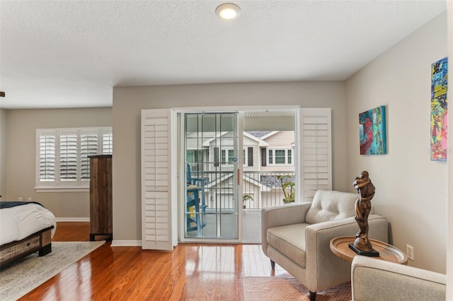 living area featuring hardwood / wood-style flooring and a textured ceiling