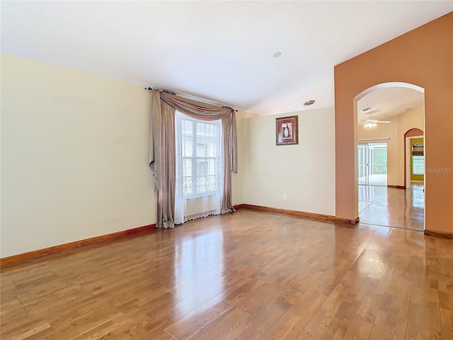 empty room featuring a healthy amount of sunlight, ceiling fan, and light hardwood / wood-style flooring