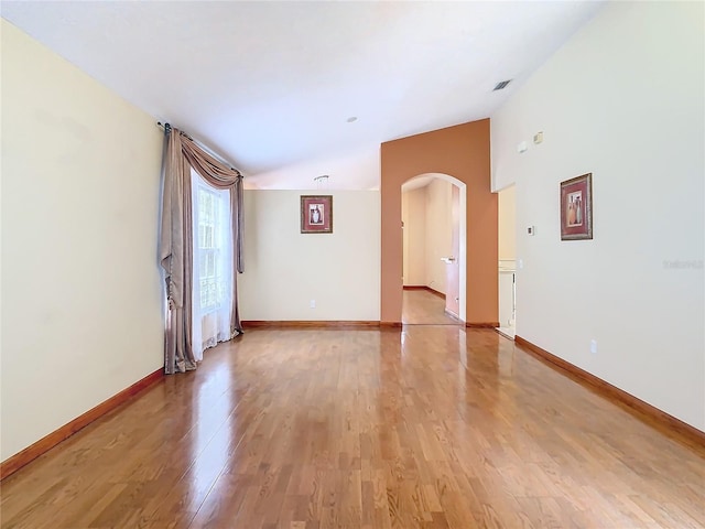 unfurnished room featuring vaulted ceiling and light hardwood / wood-style flooring