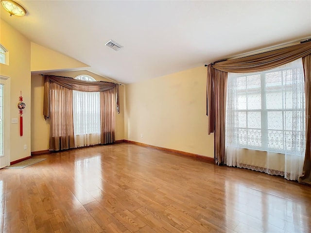 spare room with lofted ceiling and light hardwood / wood-style floors