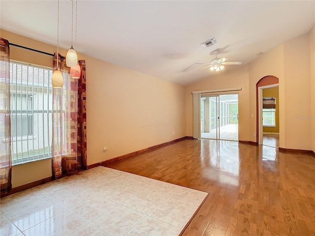 unfurnished room with ceiling fan, light hardwood / wood-style floors, and vaulted ceiling