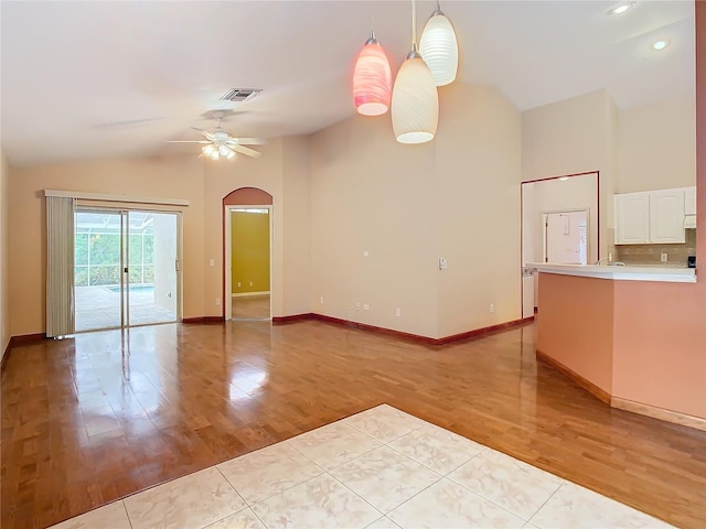 empty room featuring light wood-type flooring, ceiling fan, and vaulted ceiling