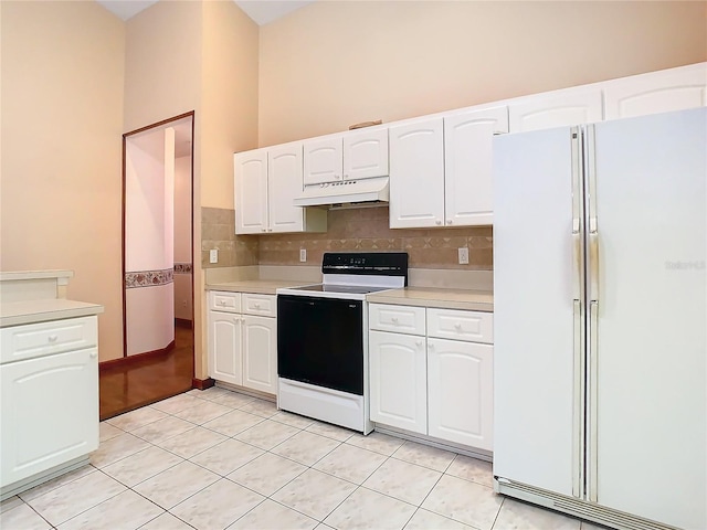 kitchen with white fridge, white cabinets, range with electric stovetop, and light tile patterned floors