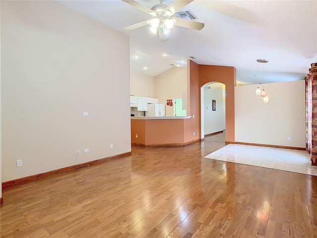 spare room with ceiling fan, light wood-type flooring, and vaulted ceiling