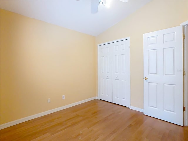 unfurnished bedroom with vaulted ceiling, hardwood / wood-style flooring, and ceiling fan