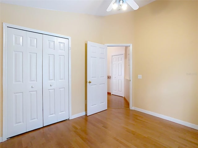 unfurnished bedroom with ceiling fan, hardwood / wood-style floors, and a closet